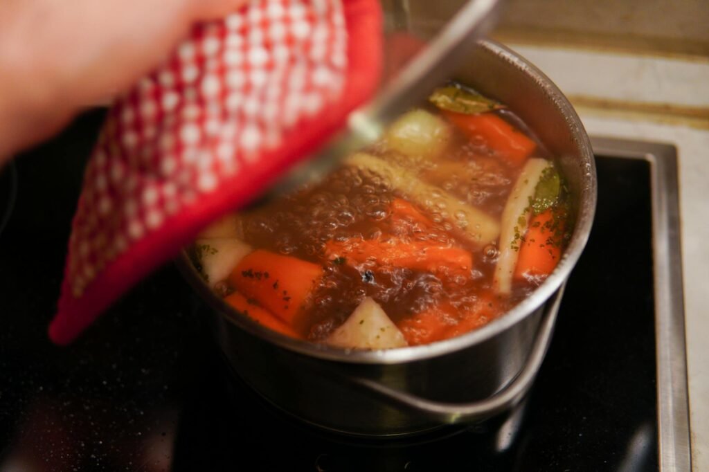 A cook tasting a spoonful of lentil stew over the stove