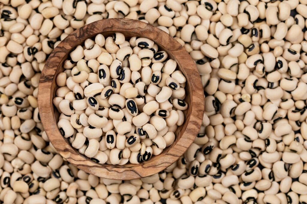Dried black-eyed peas, rice, cornmeal, and a handwritten shopping list arranged on a table.