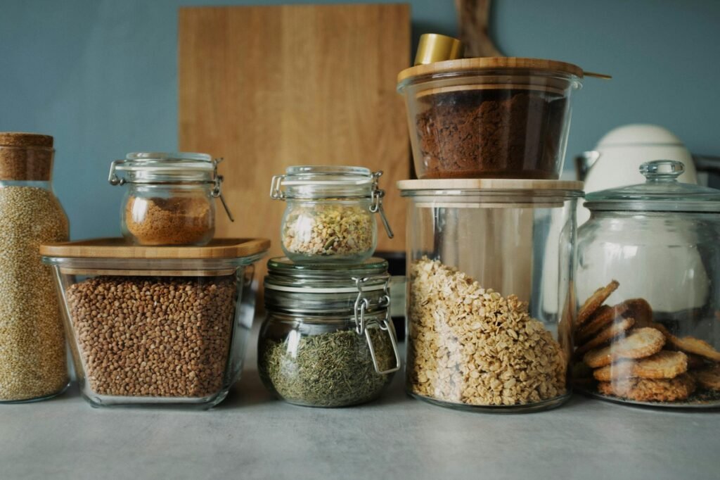 A pantry shelf stocked with baking staples in labeled jars