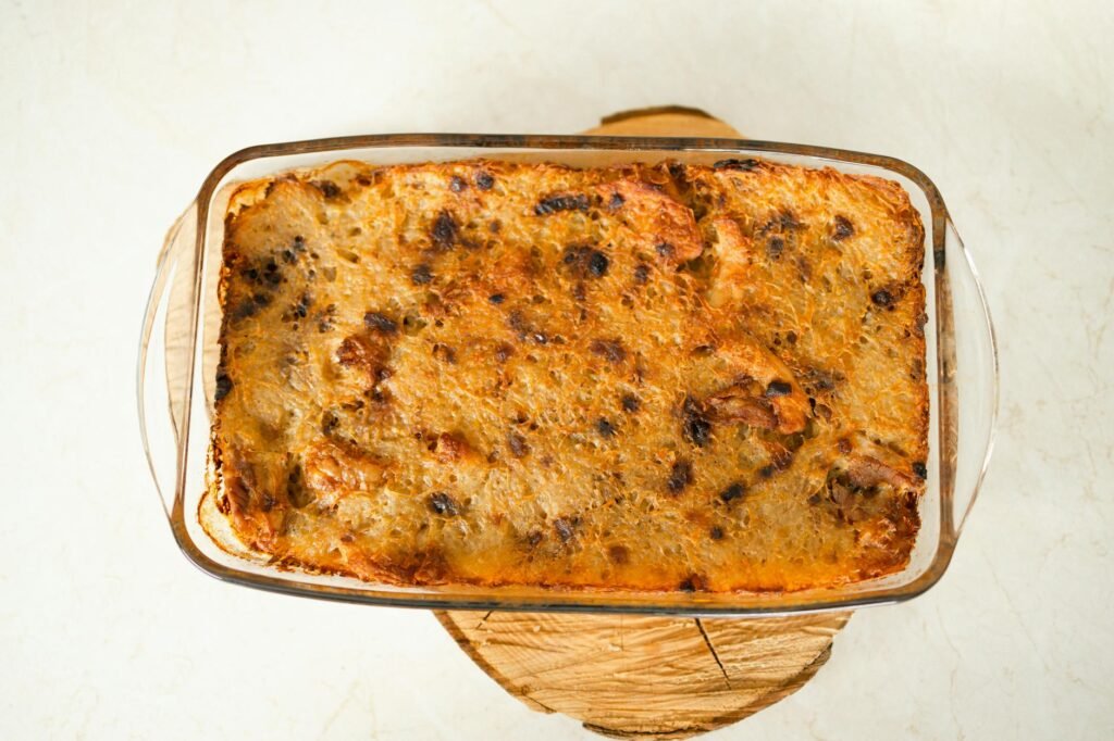 A baked pasta casserole with a browned top in a casserole dish on a kitchen towel.