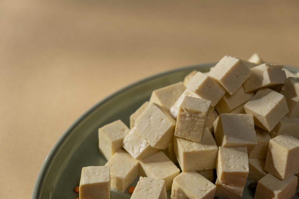 Seasoned tofu pieces on a sheet pan ready to roast