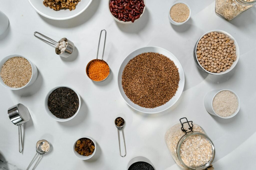 Dry beans, rice, tomato paste, vinegar, soy sauce, and mustard lined up on a kitchen counter
