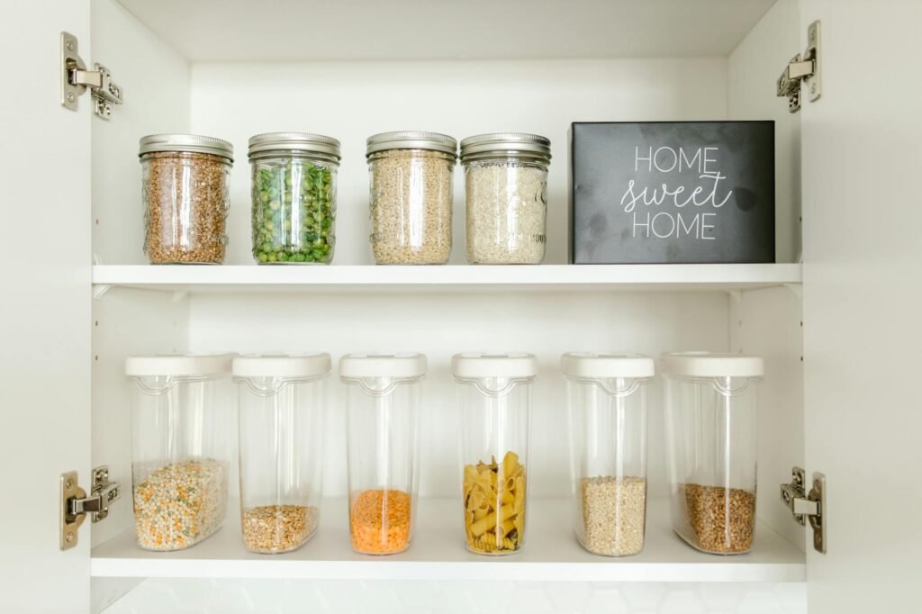 An organized pantry shelf with beans, lentils, grains, and spices