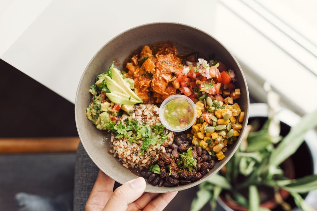 Meal-prep containers with black beans, lentils, chickpeas, rice, and toppings.