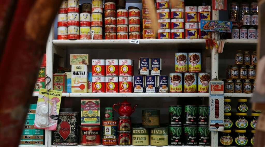 A shopper comparing unit prices on shelf labels in a grocery aisle