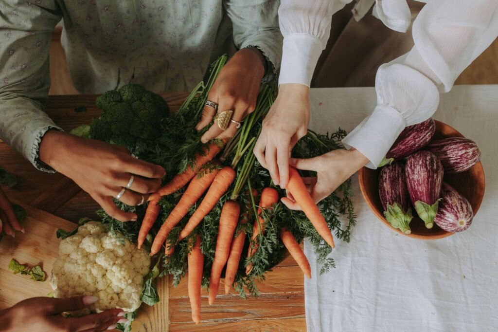 A sheet pan of roasted vegetables next to a small bowl of creamy sauce
